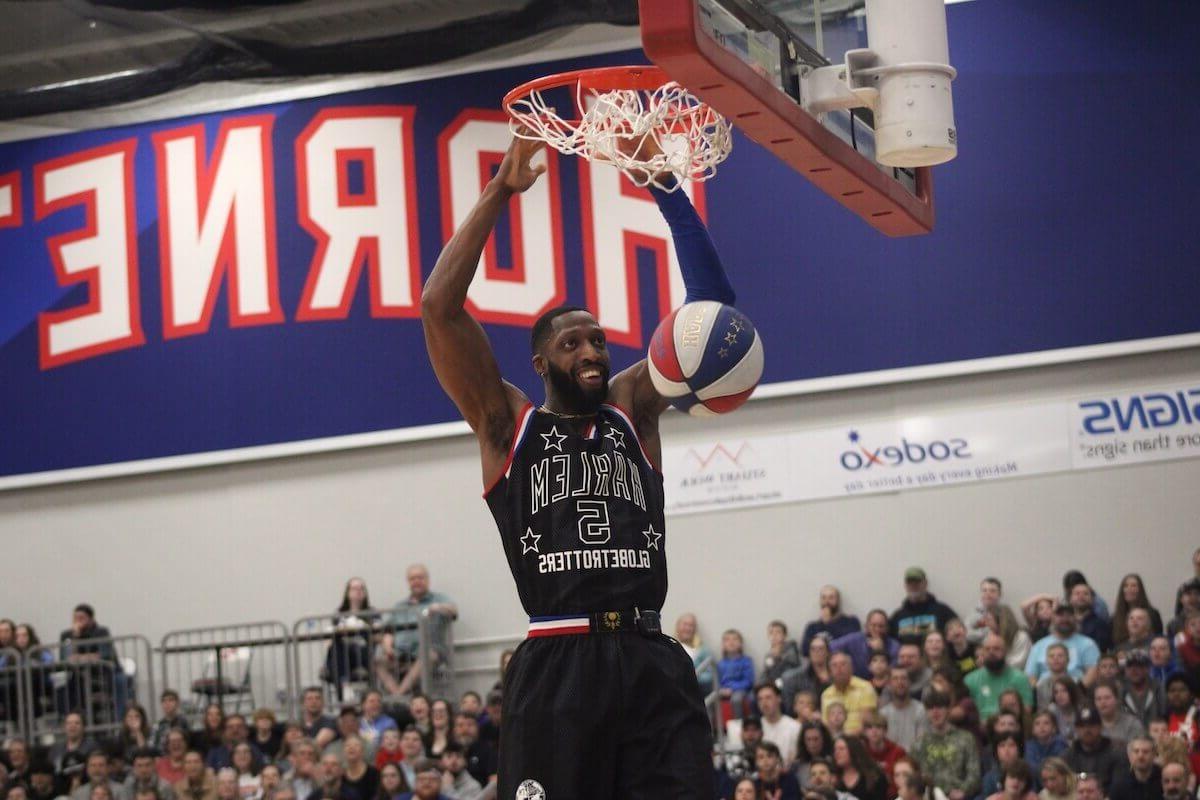 Harlem Globetrotters player Bulldog Mack dunks a basketball.